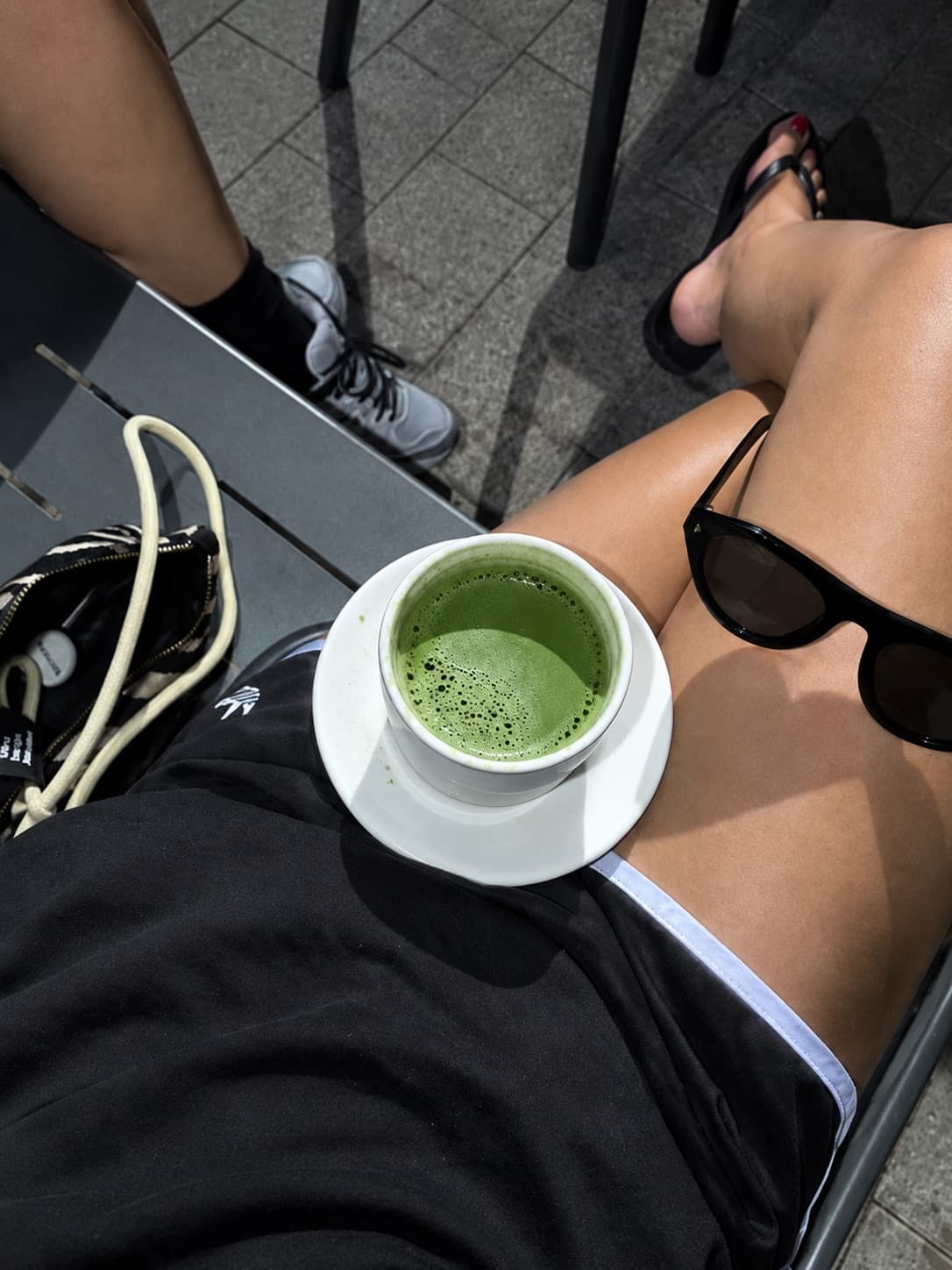 Chávena de matcha ao colo, numa esplanada ao sol